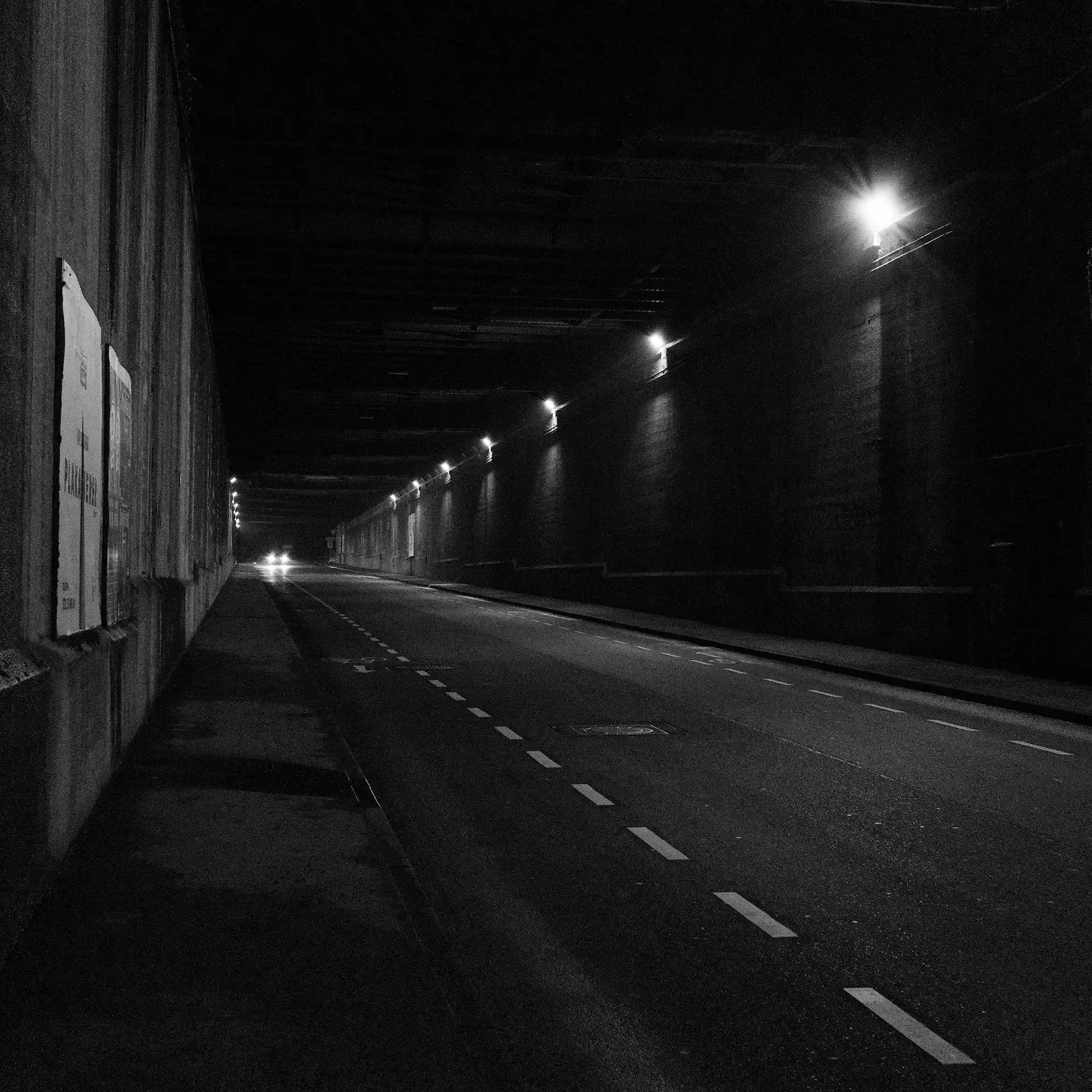 The scenery looks like a tunnel but technically its a series of many bridges. The headlines of a car are at the end of the construction.