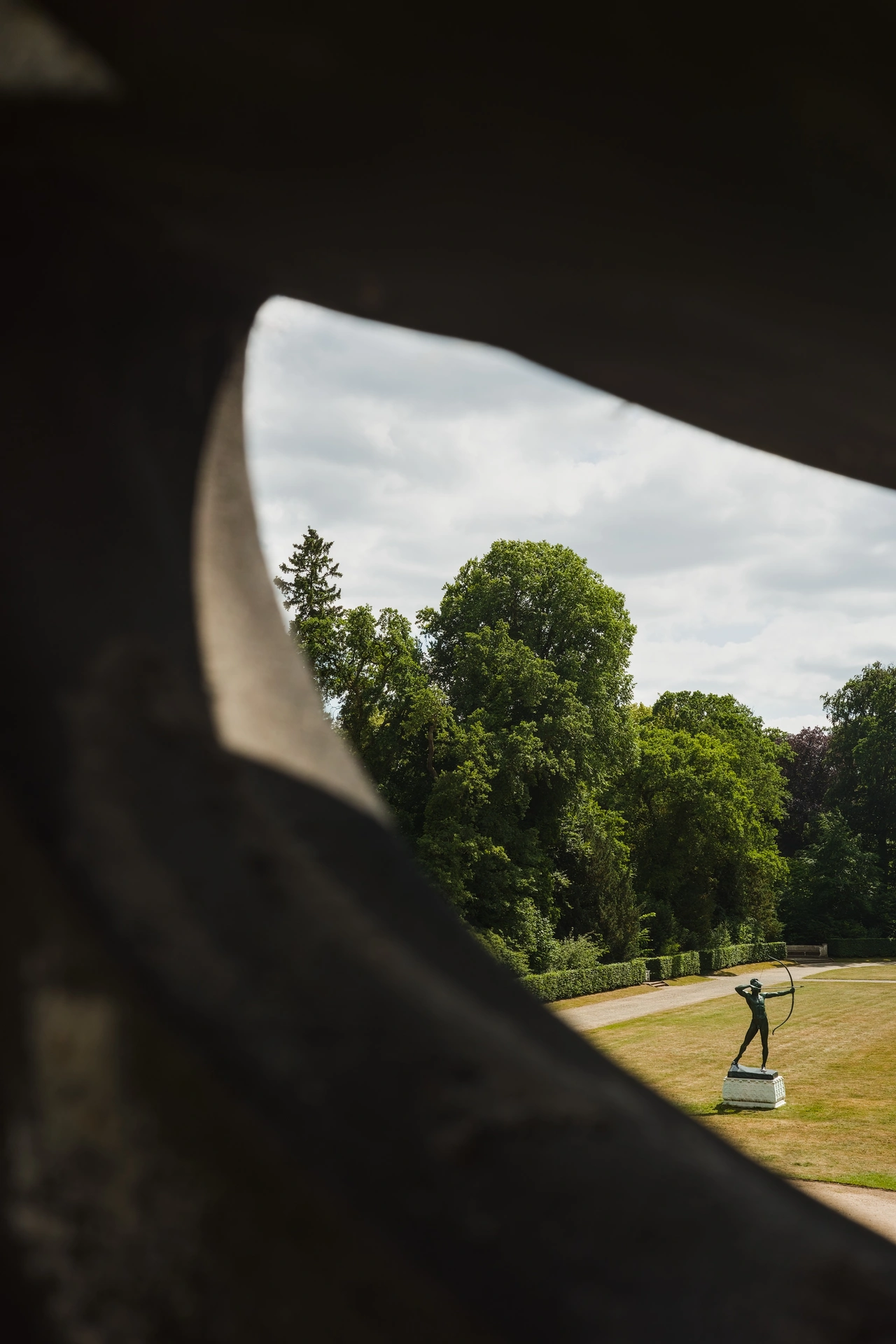 Photo of an archer sculpture framed by unidentifieable stone element.